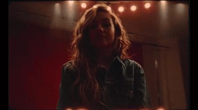 a woman with long hair standing in a room