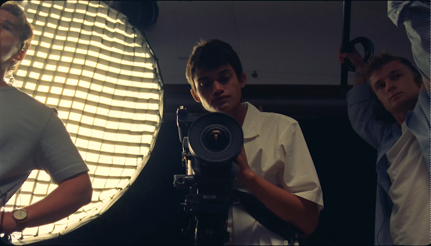 a group of people standing around a camera