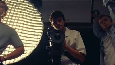 a group of people standing around a camera