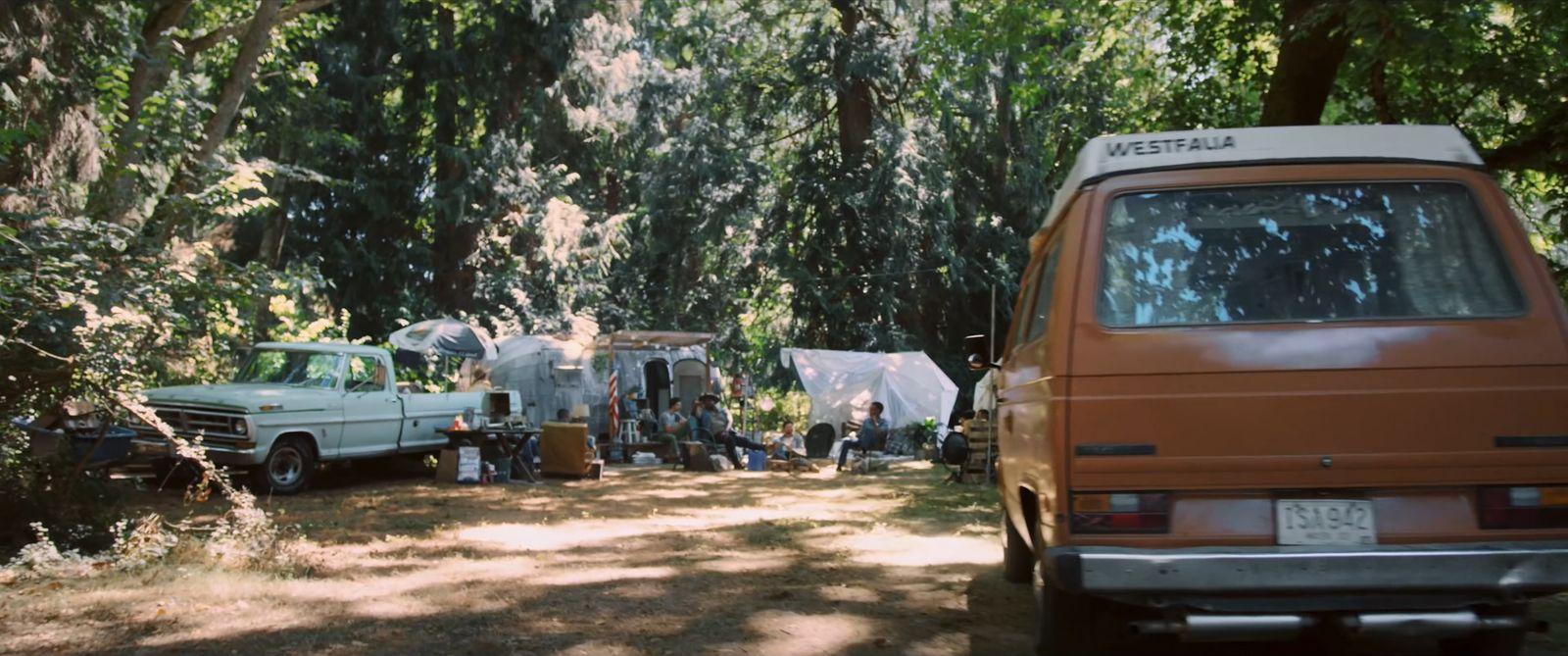a couple of trucks parked next to each other in a forest