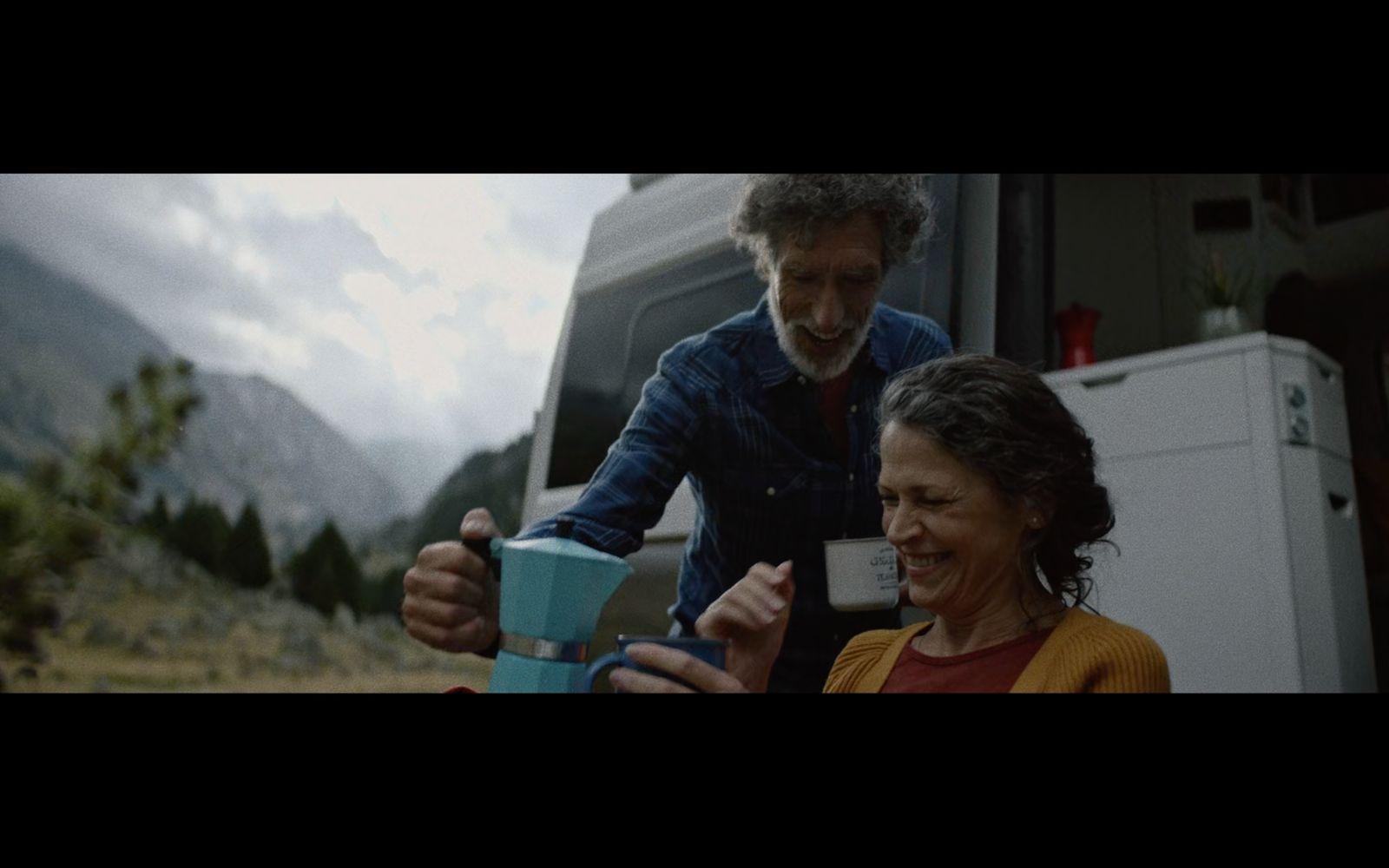 a man and a woman standing in front of a camper