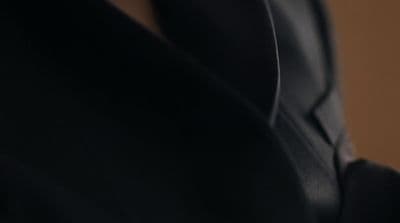 a close up of a person wearing a suit and tie