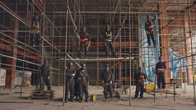 a group of men standing on top of scaffolding