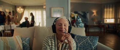 a woman sitting on a couch with headphones on