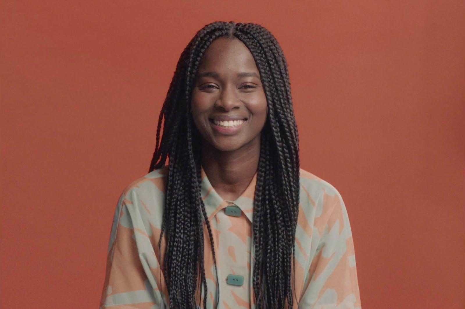 a woman with long braids smiling at the camera