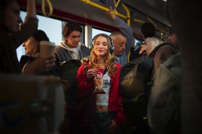 a group of people standing on a bus next to each other