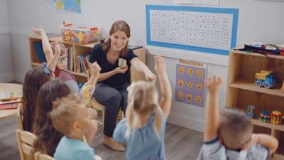 a woman sitting in a chair surrounded by children