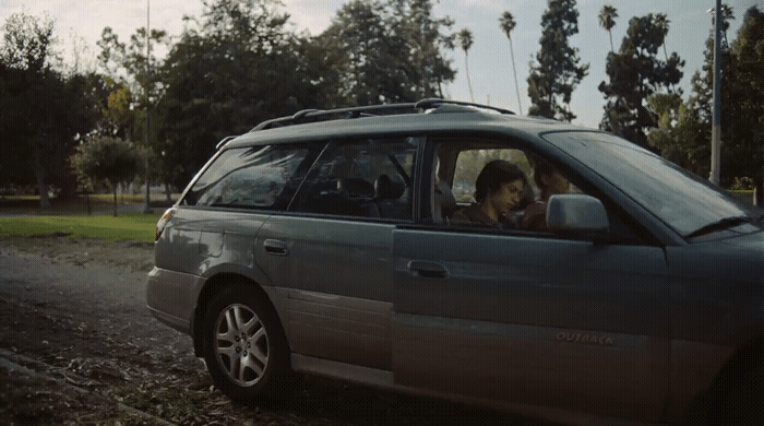 a dog sitting in the driver's seat of a car