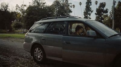 a dog sitting in the driver's seat of a car