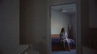 a woman sitting on a bed in a room