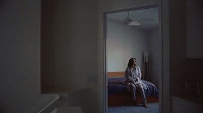 a woman sitting on a bed in a room
