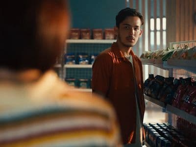 a man standing in front of a shelf of food
