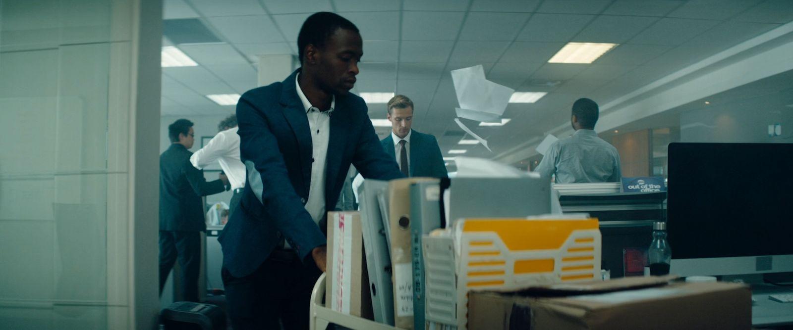 a man in a suit and tie standing in an office