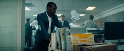 a man in a suit and tie standing in an office