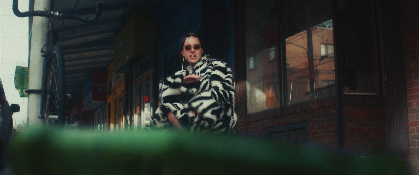 a man in a zebra print coat and sunglasses