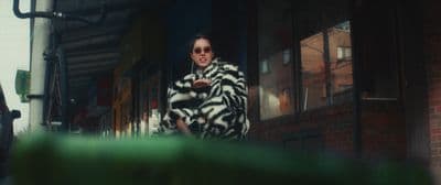 a man in a zebra print coat and sunglasses