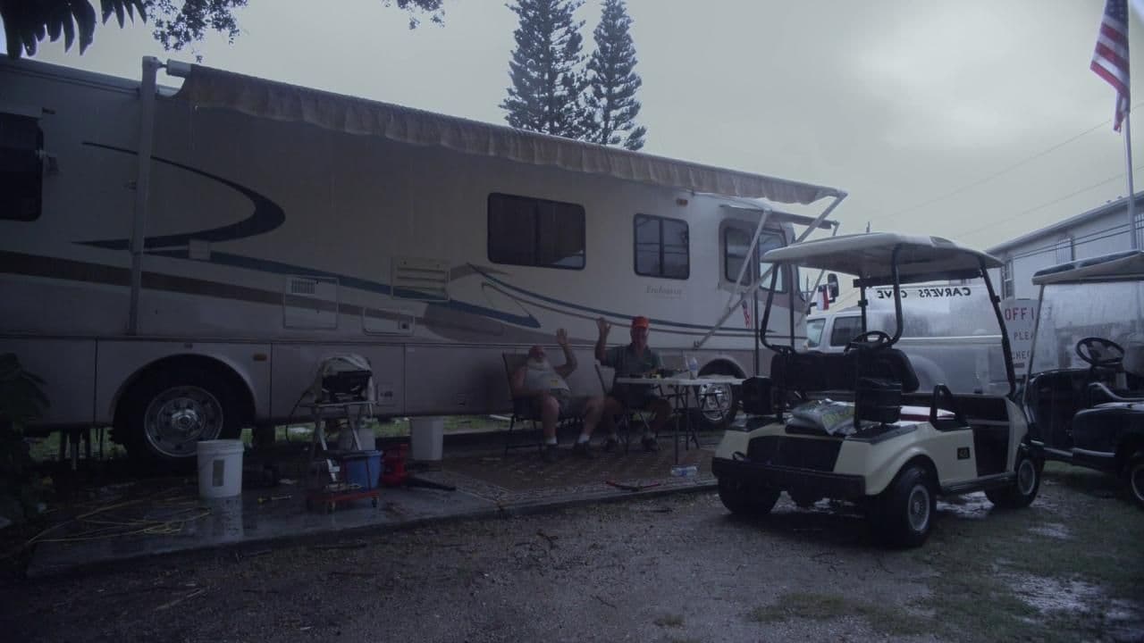 a group of people sitting in front of a motor home
