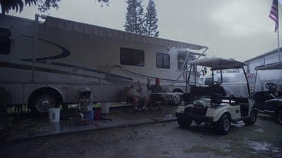 a group of people sitting in front of a motor home