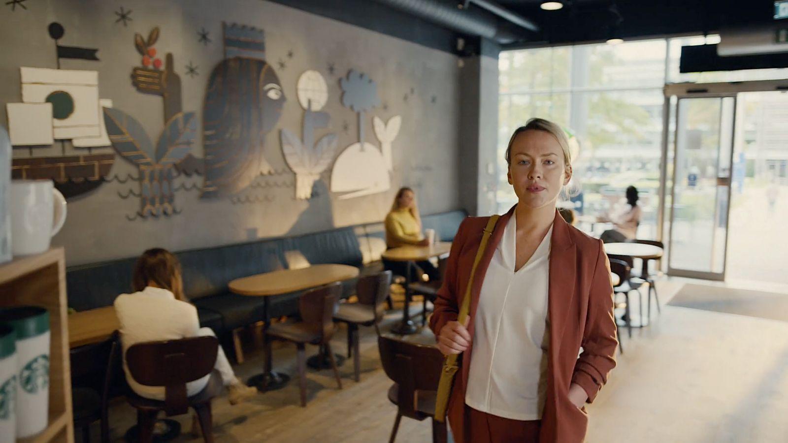 a woman standing in front of a wall with pictures on it