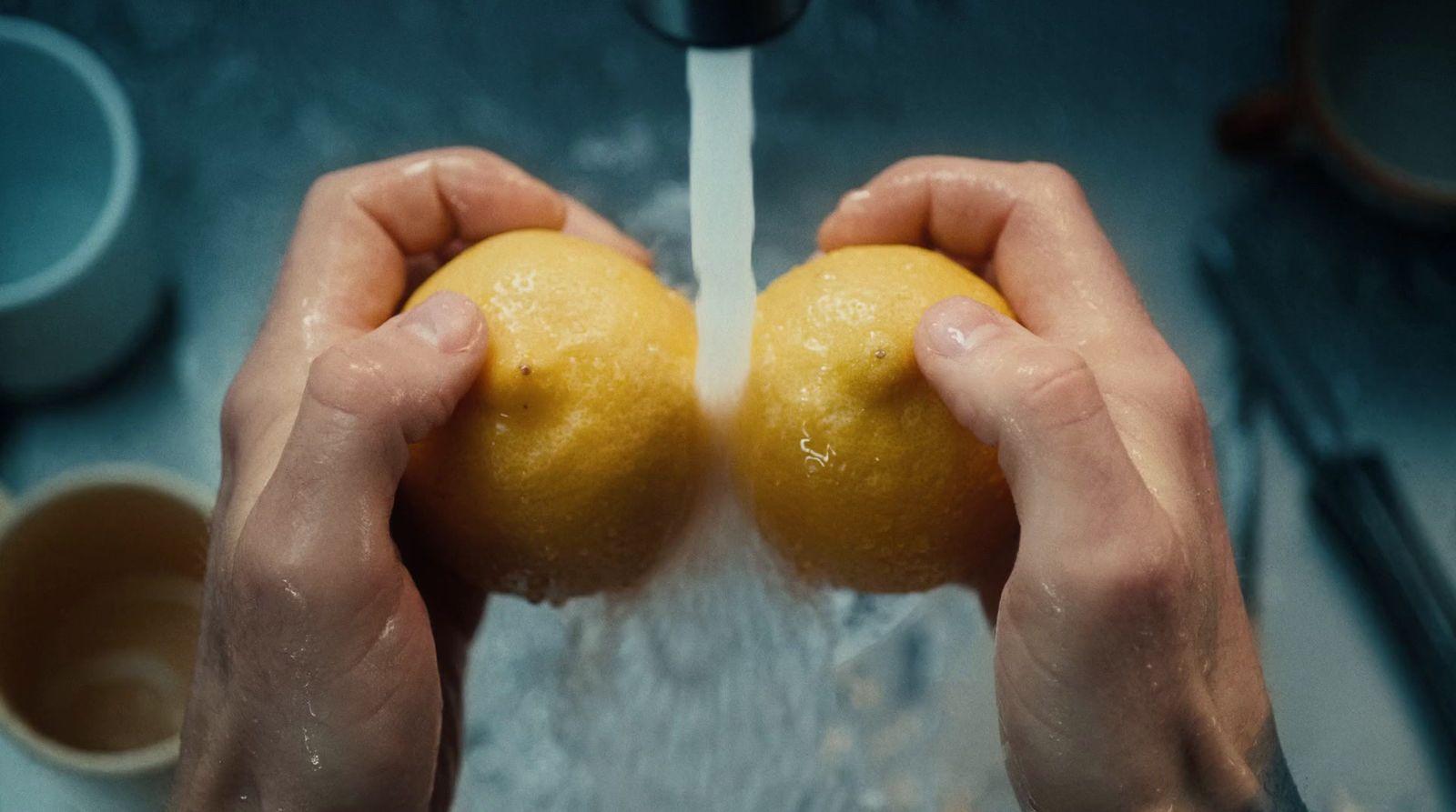 a person holding two oranges in their hands