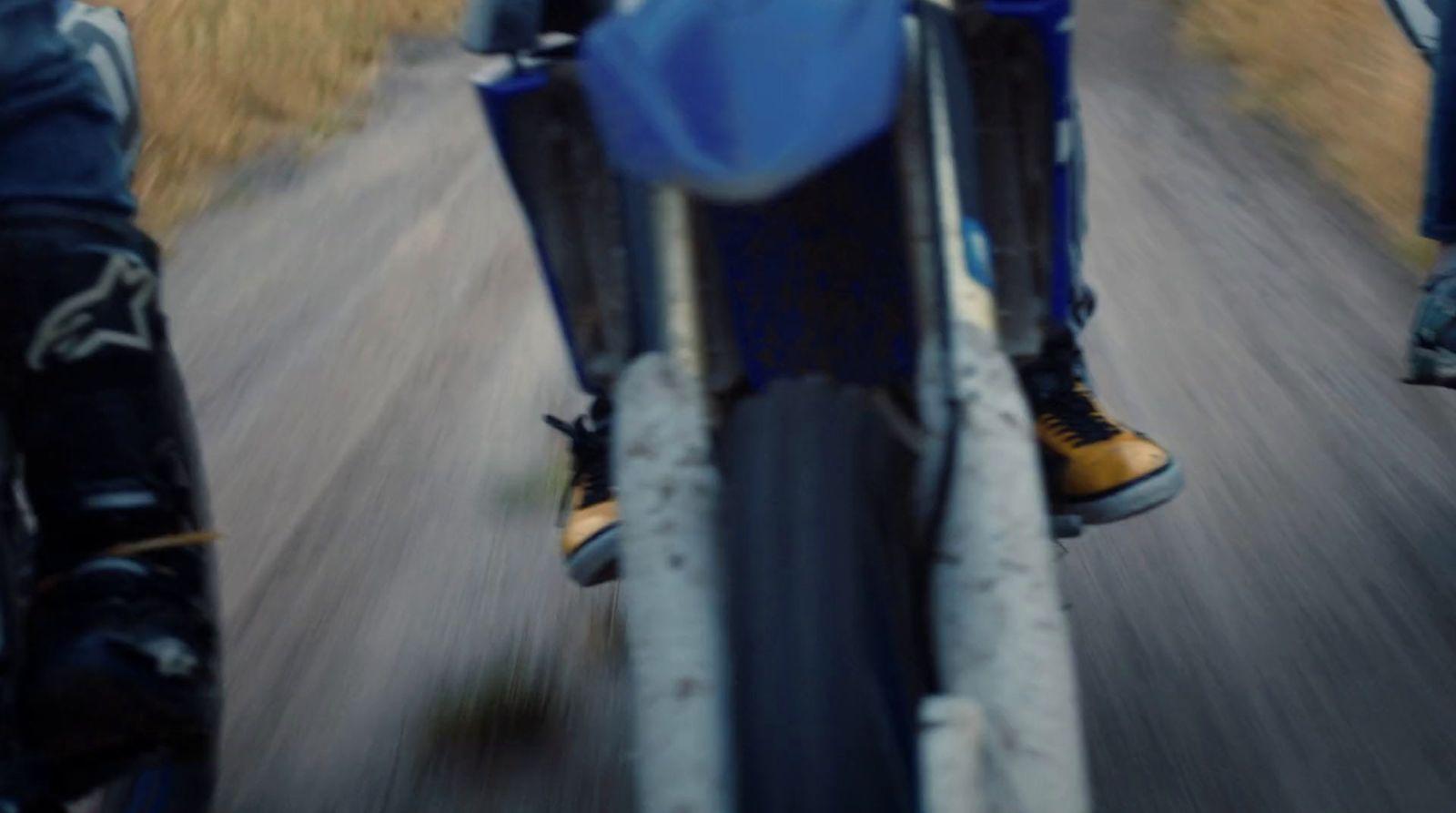 a person riding a motorcycle down a country road