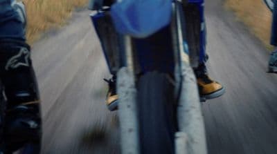 a person riding a motorcycle down a country road