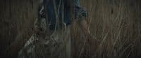 a person walking through a field of tall grass