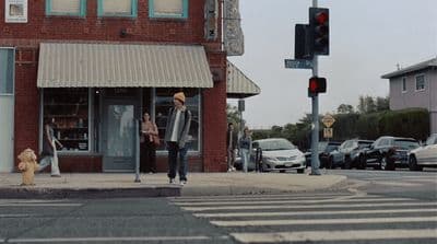 a man walking across a street next to a traffic light