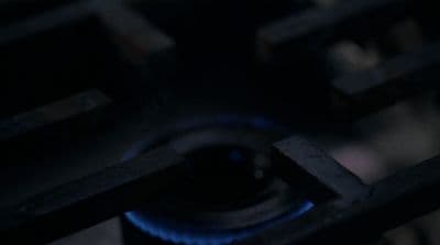 a close up of a gas stove with a blue flame