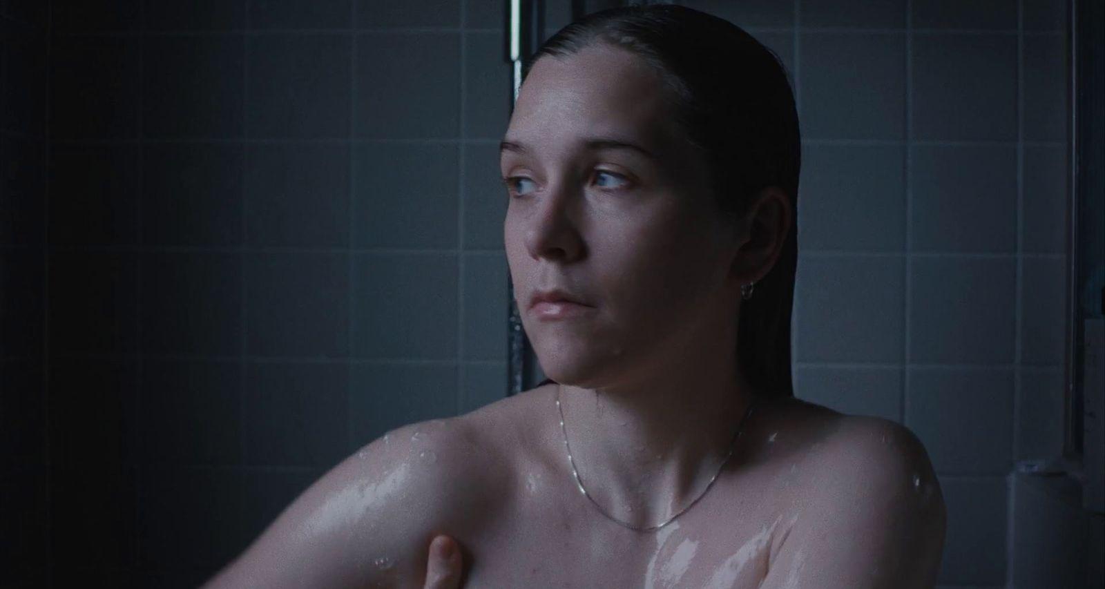 a woman in a shower with no shirt on