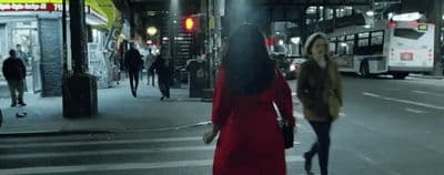 a woman in a red dress is crossing the street