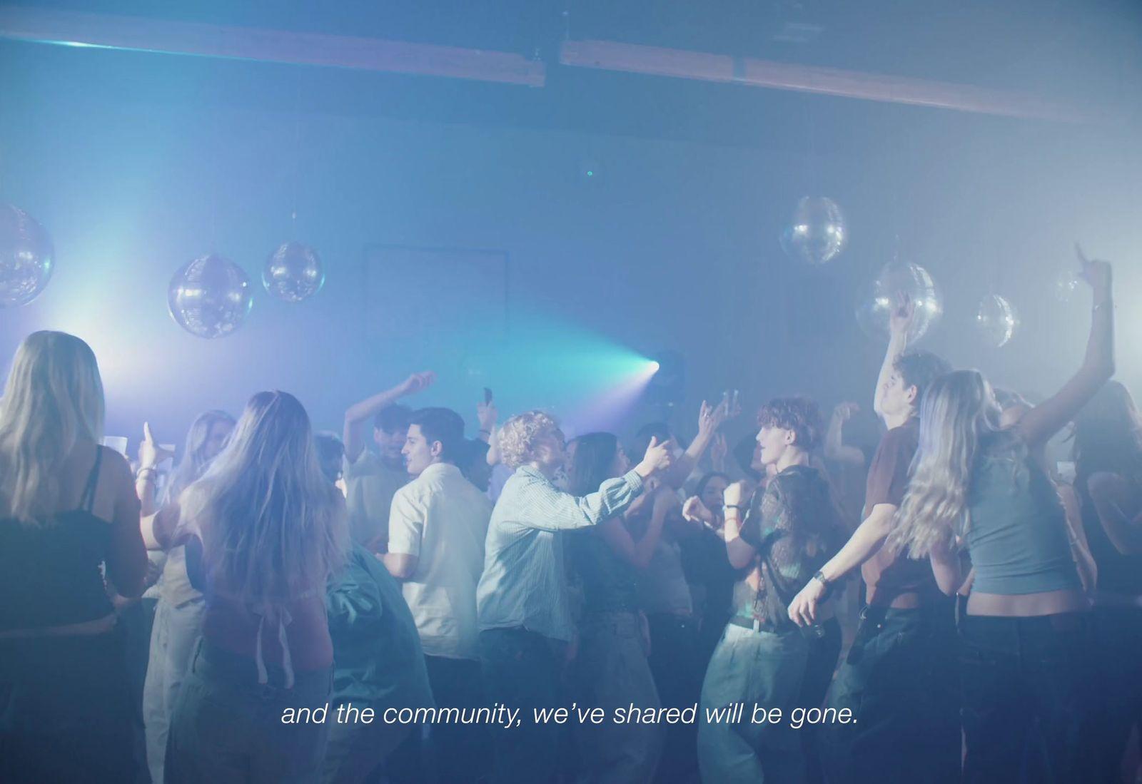 a group of people standing around each other on a dance floor
