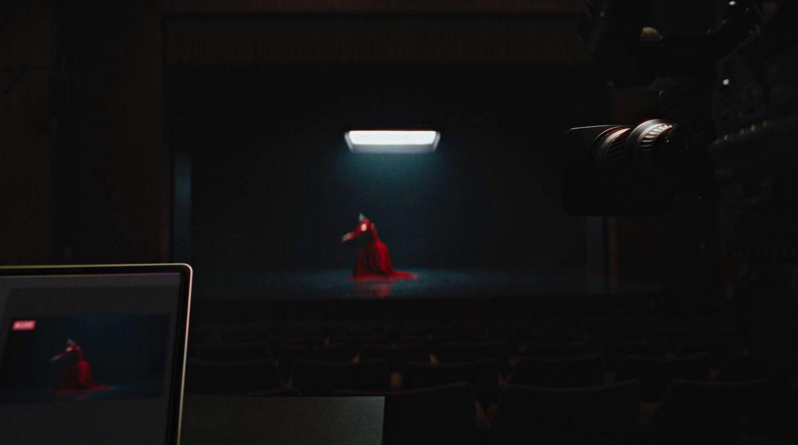 a woman in a red dress standing in a dark room