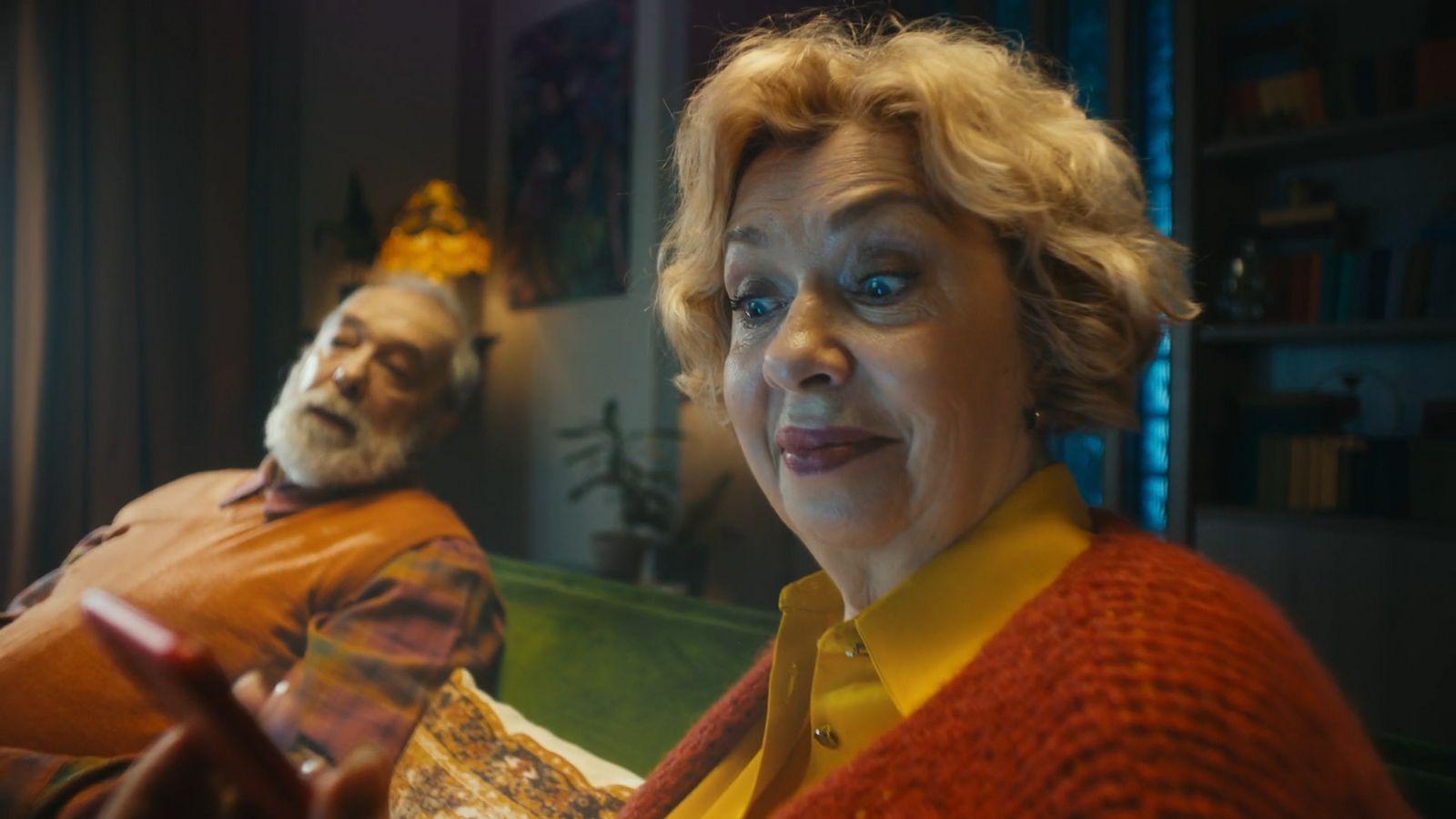 a woman sitting next to a man on a couch