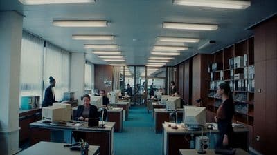 a group of people sitting at desks in an office