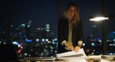 a woman standing at a desk with a lot of papers