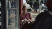 a woman sitting at a table with a plate of food