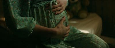 a woman in a green dress holding her stomach