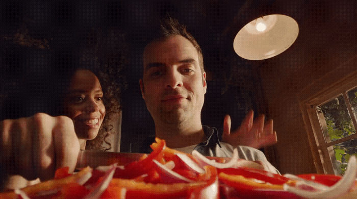 a man and a woman standing in front of a plate of food