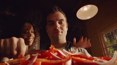 a man and a woman standing in front of a plate of food