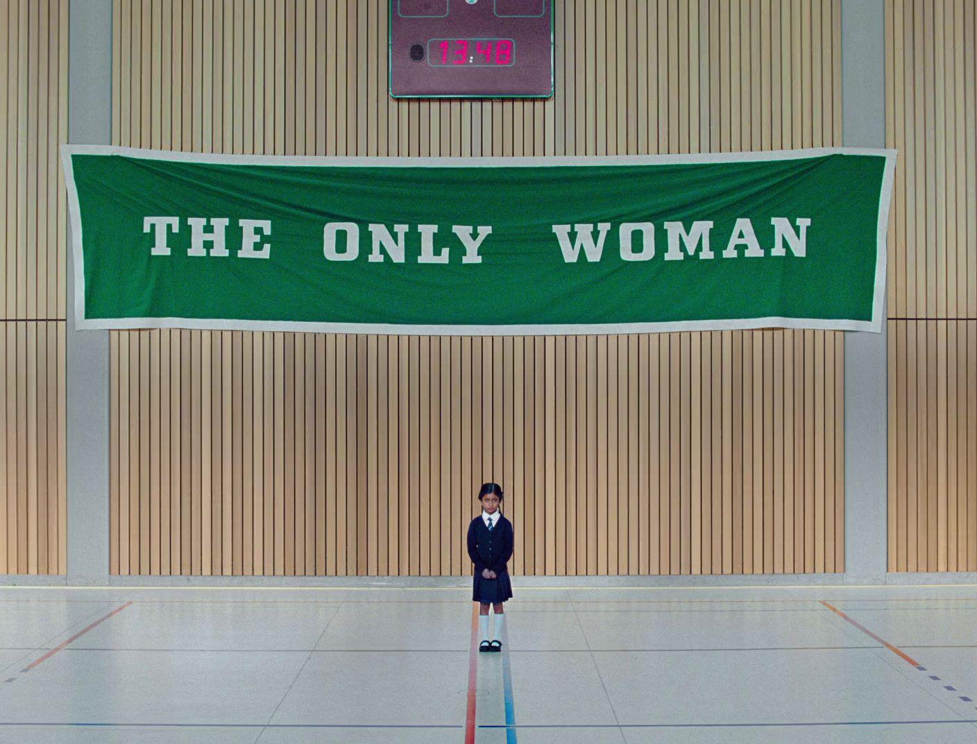 a man standing in front of a green banner that says the only woman