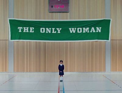 a man standing in front of a green banner that says the only woman