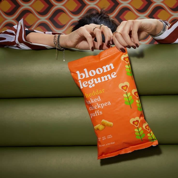 a woman holding a bag of bloom legume