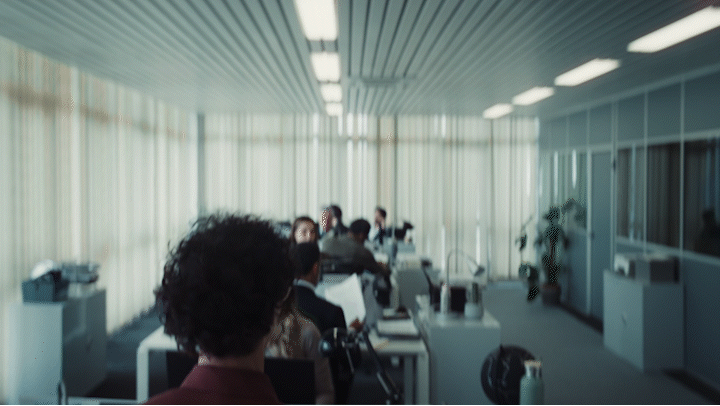 a group of people sitting at desks in a room