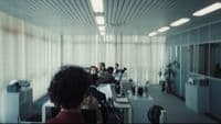 a group of people sitting at desks in a room