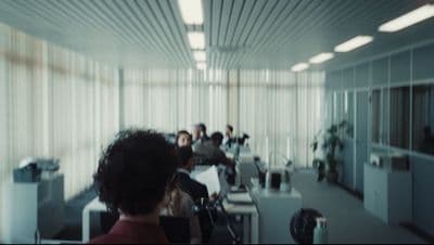 a group of people sitting at desks in a room