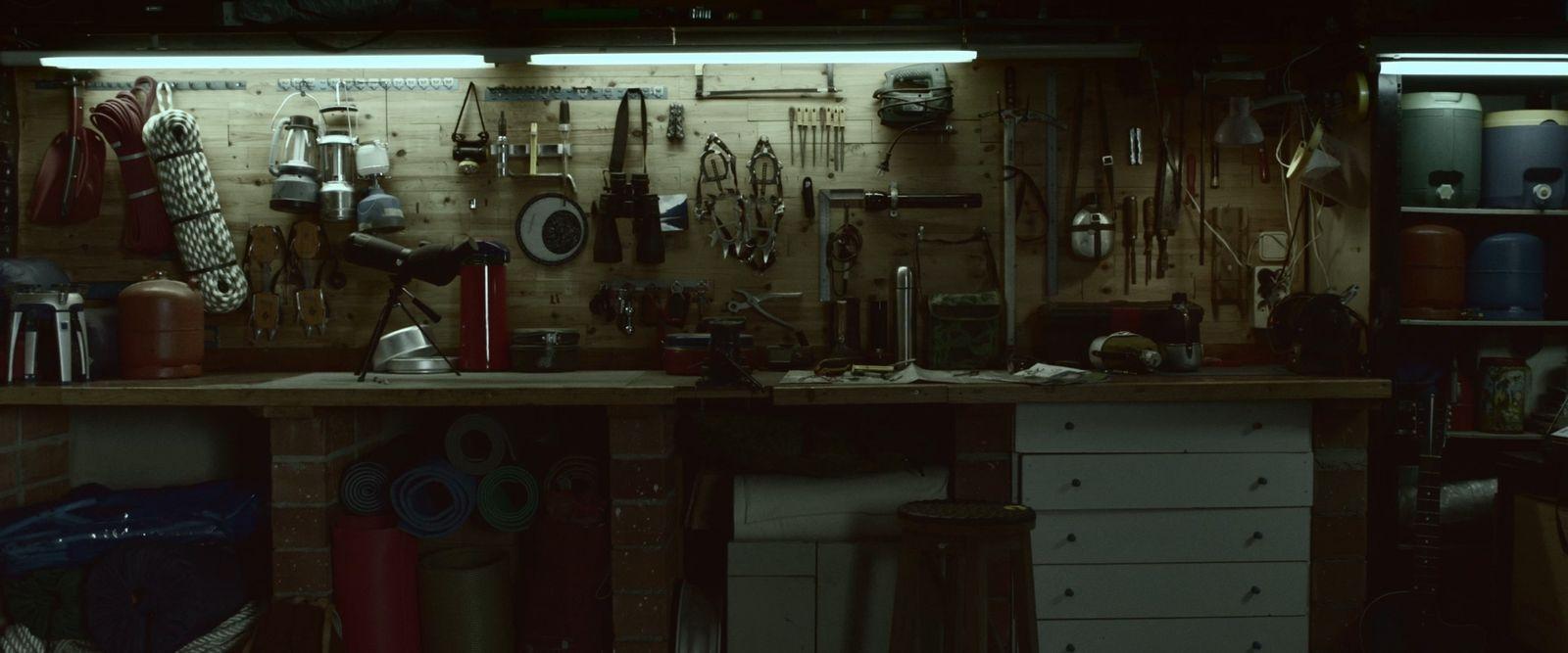 a workbench with lots of tools hanging on the wall
