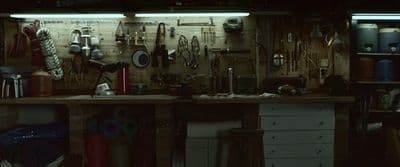 a workbench with lots of tools hanging on the wall