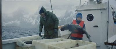 a couple of people on a boat with a bird