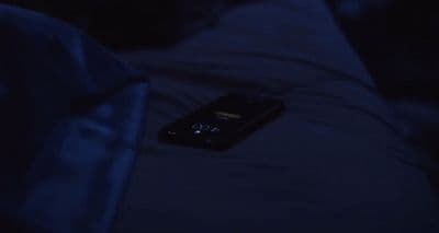 a cell phone sitting on top of a bed in the dark